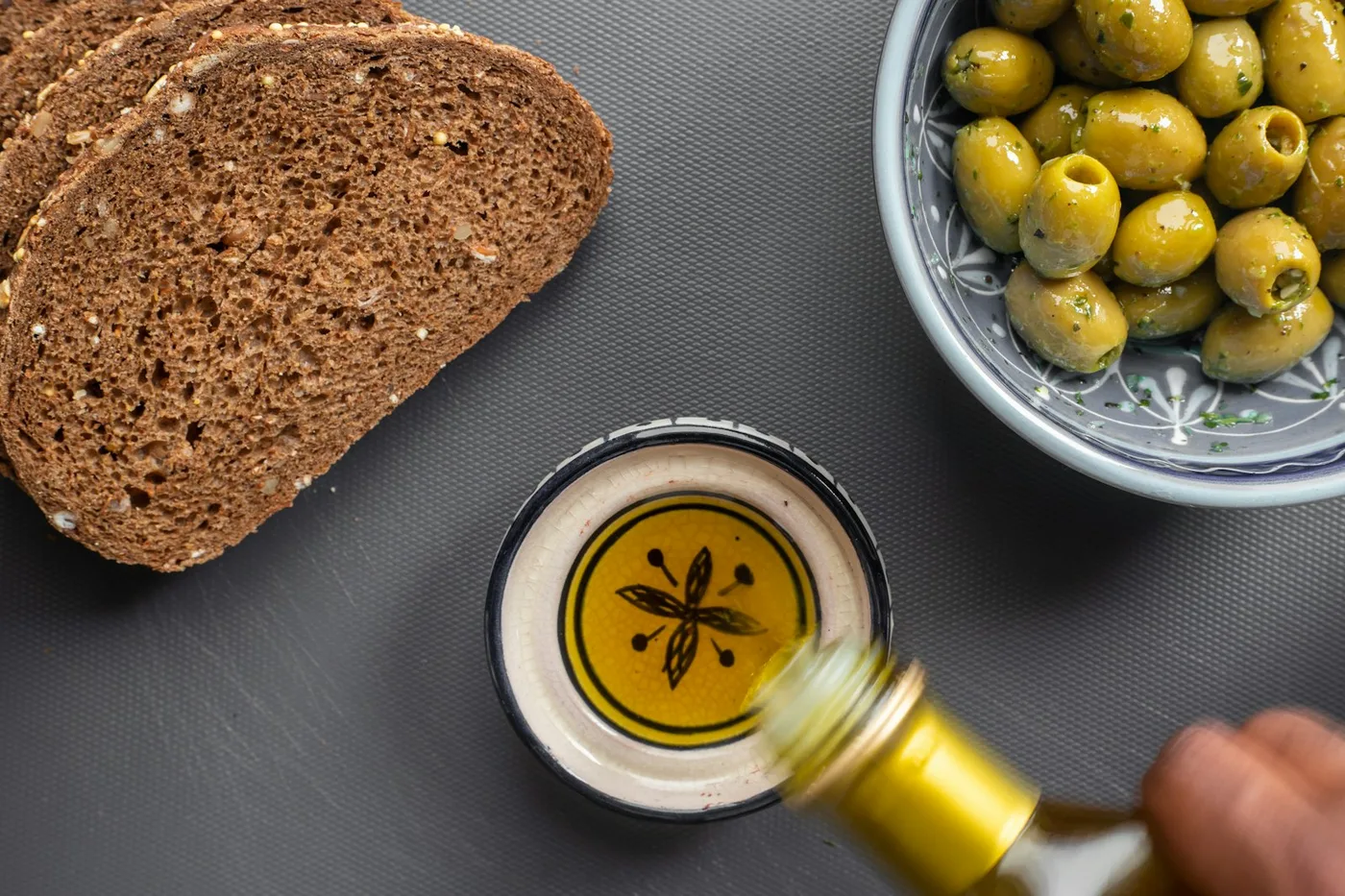 Bread dipped in olive oil with olives